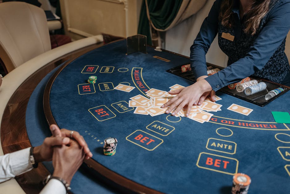 Close-up of a casino dealer shuffling cards on a gambling table with chips and bet labels.