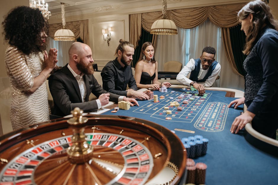 A group of people engaged in a casino game around a roulette table indoors.